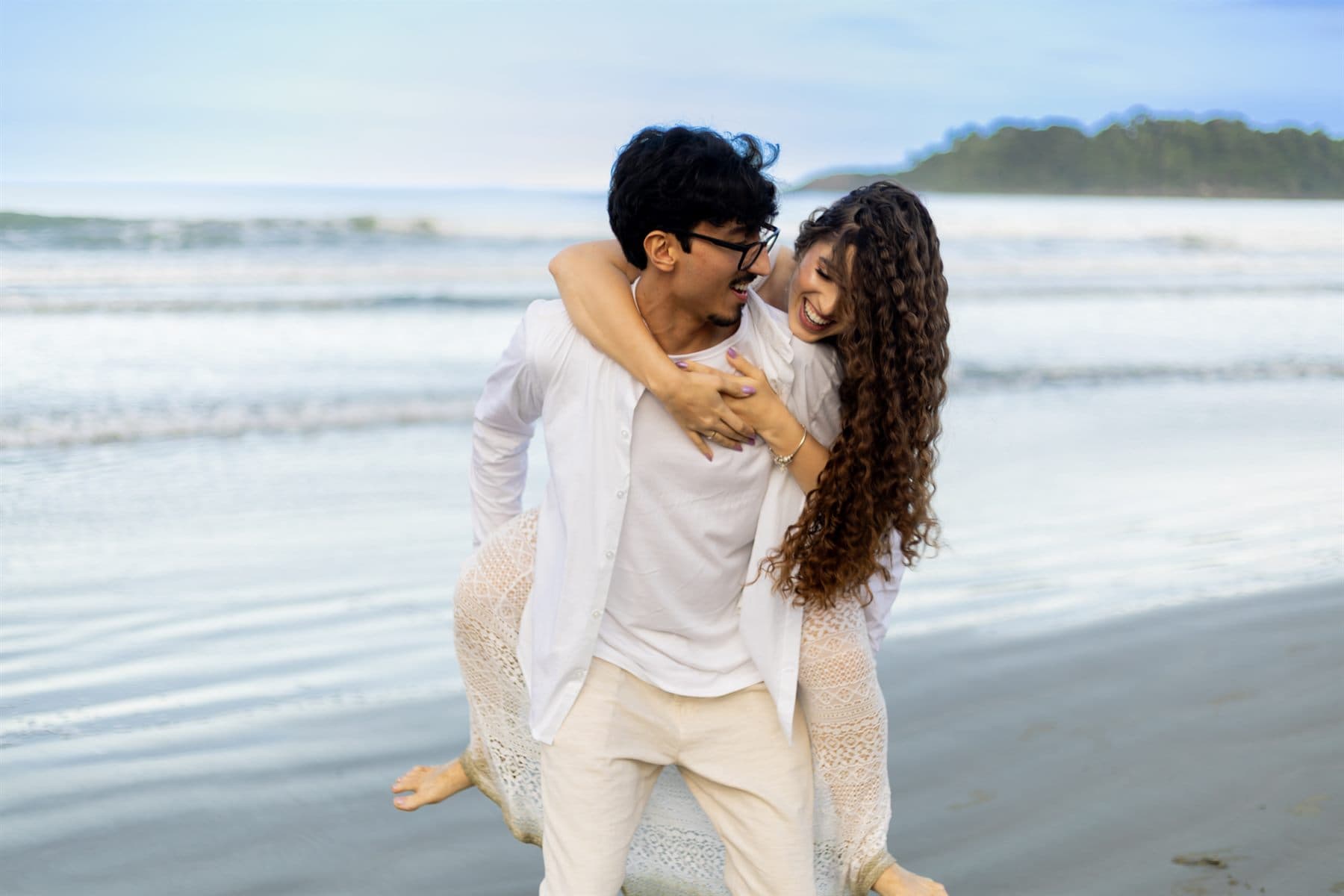 Brincadeira do casal na beira do mar, entre risadas